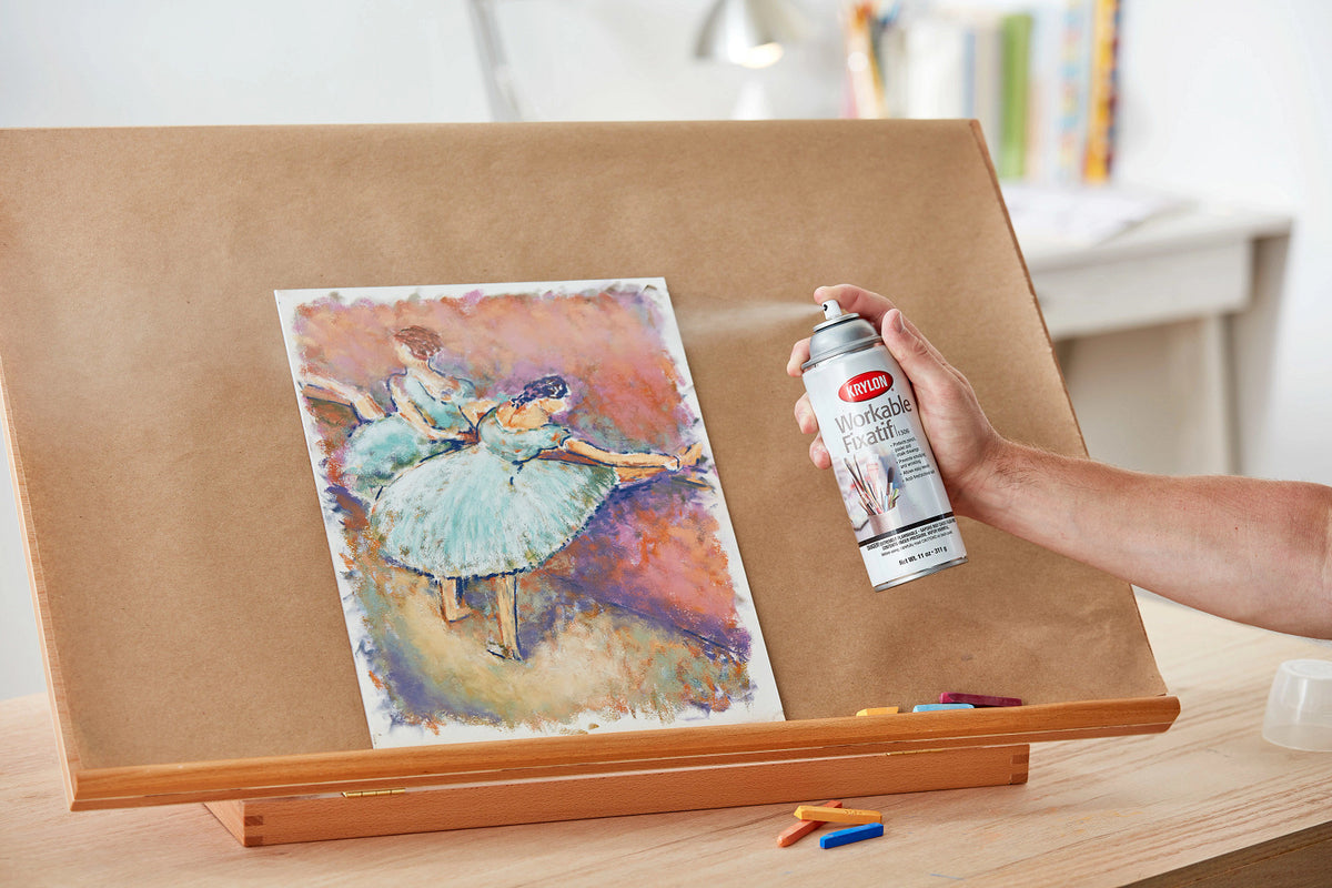 Applying Krylon Workable Fixatif spray to artwork