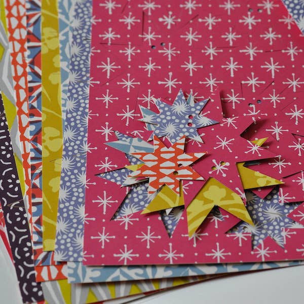 Close-up of assorted patterned card sheets with press-out stars in pink, blue, yellow and orange